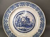 a blue and white plate with a picture of a boat on it
