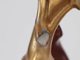 a close up of a gold cane with a red handle