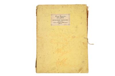 un vieux livre jaune, sur lequel on voit des inscriptions, posé sur une surface blanche