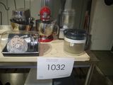 une table sur laquelle se trouvent un mixeur, un batteur, un blender et d'autres ustensiles de cuisine