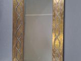 miroir avec un cadre doré et un motif décoratif