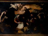 tableau représentant un groupe de personnes rassemblées autour d'un tableau représentant Jésus sur la croix