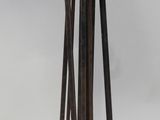 une sculpture métallique représentant une personne tenant un balai et un balai