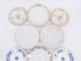 several different types of china plates are arranged on a white surface