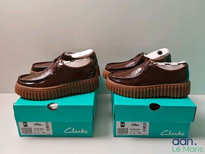 two brown shoes are sitting on top of a blue box