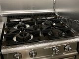 une cuisinière en acier inoxydable dans une cuisine dotée de nombreux plans de travail