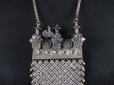 une femme portant un collier composé de perles en argent et d'une chaîne