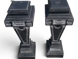pair of black marble pedestals with a book on top