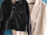 two jackets hanging on a blue wall next to a pair of shoes