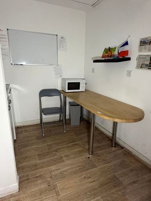 une table avec un micro-ondes et une chaise dans la pièce