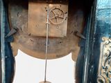 a clock that has a pendulum on the side of it