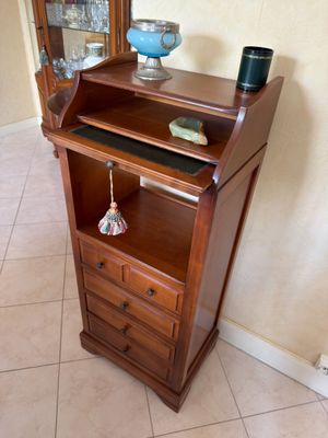 a wooden cabinet with a glass door and a blue vase on top of it