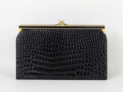 une pochette en cuir de crocodile noir avec un fermoir doré