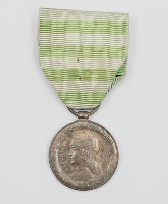 une image représentant une médaille entourée d'un ruban et sur laquelle figure une pièce de monnaie