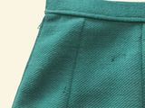 the bottom of a pair of green pants with buttons on the side