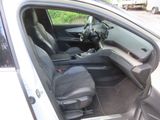 the interior of a car with the door open and the driver ' s seat down