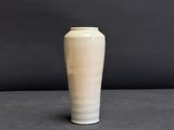 a white vase sitting on a table with a black background