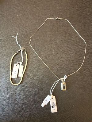 two necklaces with tags on them sitting on a table