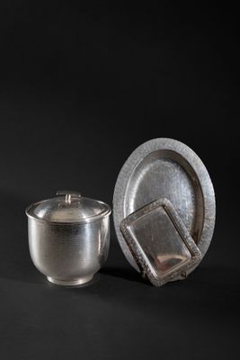 a silver cup and saucer sitting next to each other on a black background
