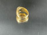 a close up of a gold ring on a black surface