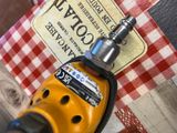 a drill that is sitting on top of a red and white checkered table cloth