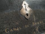 une boîte métallique munie d'un cadenas sur laquelle est inscrit « Canal de Berry »