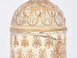 a glass jar with a gold and green decoration on it