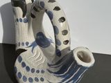 a white and blue vase sitting on a black table