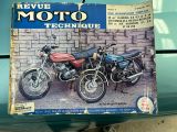 un livre posé à l'arrière d'une voiture, à côté de deux motos