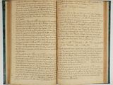 un livre ouvert avec une écriture dessus, posé sur une table