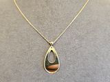 un collier avec un pendentif en forme de larme sur un mannequin, un mannequin, un mannequin, un mannequin, un mannequin, un mannequin, un mannequin, un mannequin, un mannequin