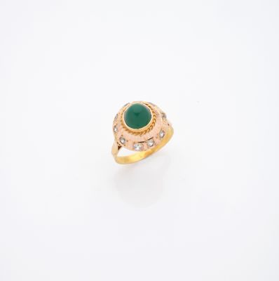 gros plan d'une bague en or avec une pierre verte
