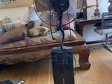 un ventilateur posé sur un pied dans un salon