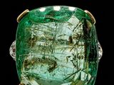 a close up of a ring with a green stone in it