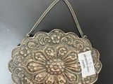 a silver purse with a tag on it sitting on a table