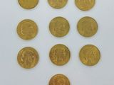 plusieurs pièces d'or sont disposées en cercle sur une surface blanche