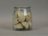 a glass jar filled with peeled bananas on a table