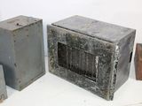 three old metal boxes sitting on a white table