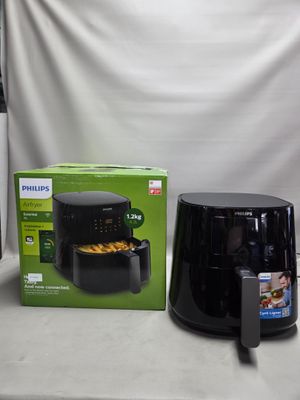 une boîte de nourriture posée sur une table à côté d'une friteuse à air chaud noire
