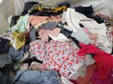a large pile of clothes in a bin on the floor