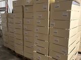 Plusieurs piles de cartons sont empilées sur des palettes dans un entrepôt