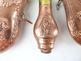 two copper shoes with a bottle of wine on them