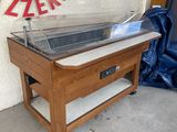 une table en bois sur laquelle est posée une casserole en métal, devant un panneau
