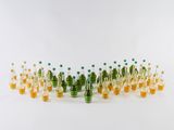 des bouteilles remplies d'un liquide orange et vert sont posées sur une surface blanche