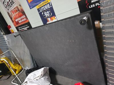un tableau noir posé par terre à côté d'une balle rouge