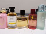 bottles of various perfumes are lined up on a table