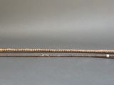 a metal pole with a wooden handle on a gray surface