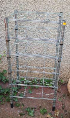 a metal rack that is next to a potted plant on the ground
