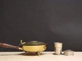 un pot jaune et une tasse en argent posés sur une table