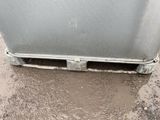 a dirty refrigerator sitting in the middle of the street